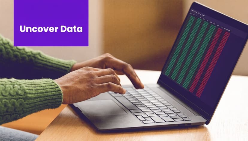 A person wearing a green sweater typing on a laptop displaying complex data analysis software.